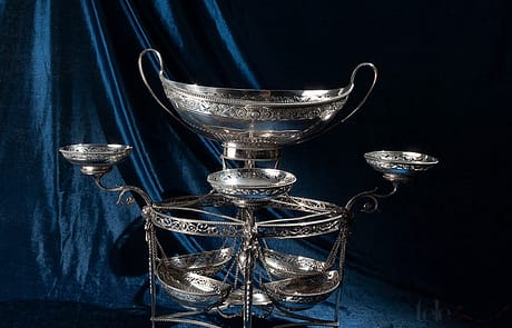 Silver epergne, London 1784 Marks of master silversmith Thomas Pitts I. Specimen published in Jackson’s Silver and Gold Marks “Epergne with central basket and outline baskets” Silver epergne, London 1784 Marks of master silversmith Thomas Pitts I. Specimen published in Jackson's Silver and Gold Marks "Epergne with central basket and outline baskets"