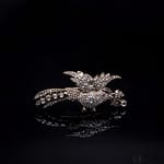 Gioielli 11 Telearte gioielli d'arte - Spilla in forma di uccello con lunga coda e con un ramo nel becco, in diamanti e rubini Decorata da 264 diamanti taglio a rosa, peso totale stimato 8,65 ct; 1 rubino rotondo taglio composito, peso stimato 0,03 ct. Peso complessivo gr. 21