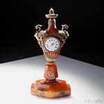 Antiquariato 26 Telearte oggetti d'arte - Orologio da tavolo in ambra, Francia 1760 Manifattura Lepine, reca due grifoni alati in bronzo dorato sui lati del quadrante, su base esagonale.